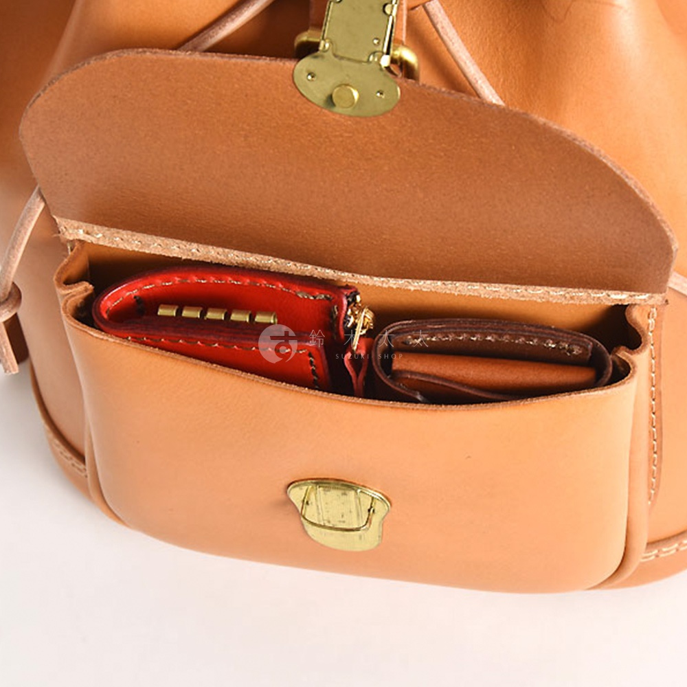 職人手作皮革經典後背包 R-4，展示其棕褐色皮革材質、金色金屬扣件，以及內部側袋中的紅色皮革鑰匙包和卡夾。