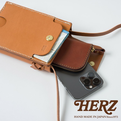 職人手作皮革手機包 CP-11，淺棕色皮革，內部有深棕色拉鍊夾層，可放入手機及卡片，搭配細長皮革背帶。