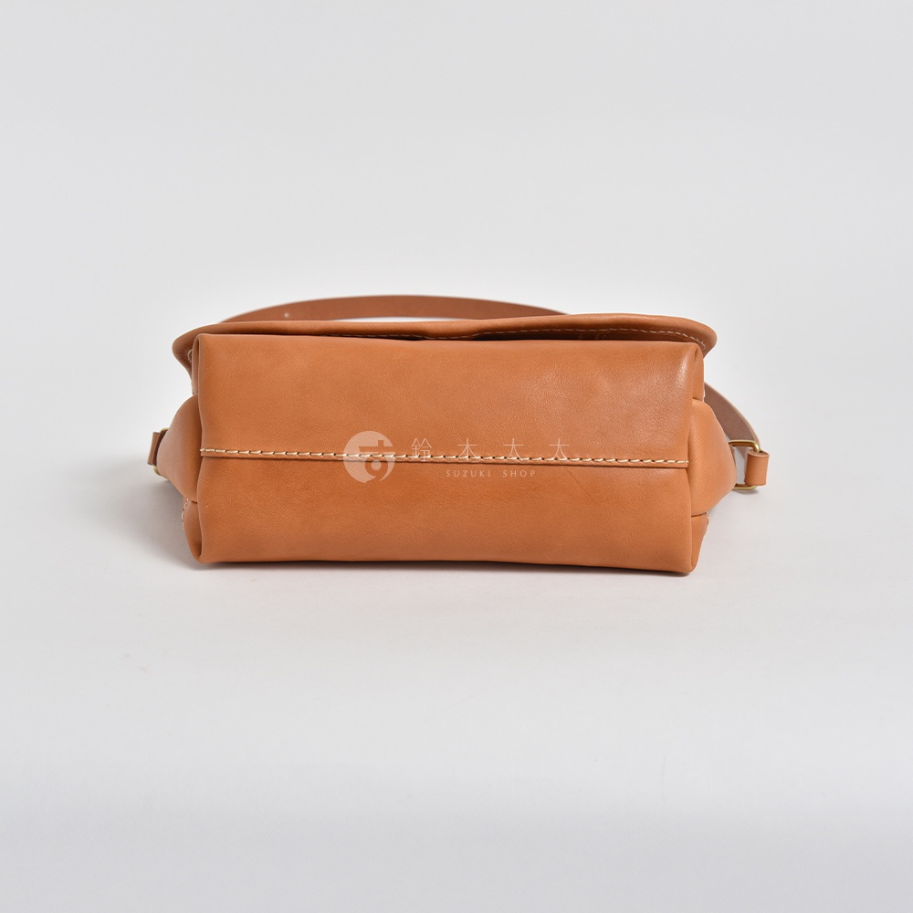 職人手作皮革復古郵差包，採用棕褐色皮革製作，包身結構方正，縫線整齊，配有可調節的皮革背帶。