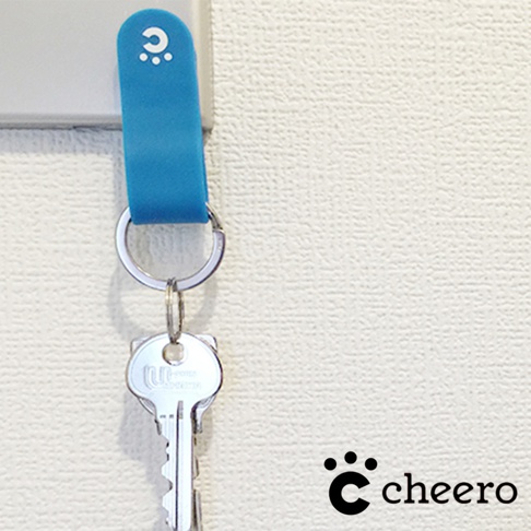 藍色矽膠製成的萬能QQ變形夾，帶有白色小圓點和圓圈的標誌，夾著一個銀色金屬鑰匙。