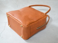 職人手作皮革Organ方形托特包，採用有紋理的棕褐色皮革，設有頂部提把、側面拉鍊和底部金屬鉚釘。