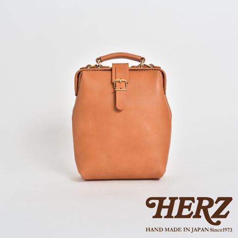 職人手作皮革迷你軟皮杜勒斯包，採用淺棕色皮革製成，配有金色釦環和手提把。