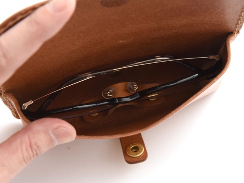 職人手作皮革眼鏡收納盒，棕褐色皮革材質，內有眼鏡一支，附有金色按扣。