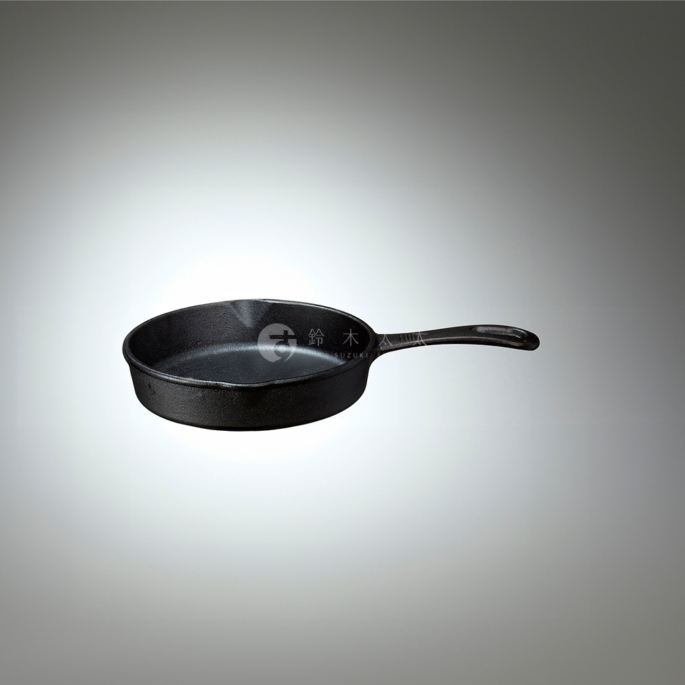 黑色鑄鐵平底鍋，鍋身圓形，帶有單長柄，鍋底有品牌標誌。