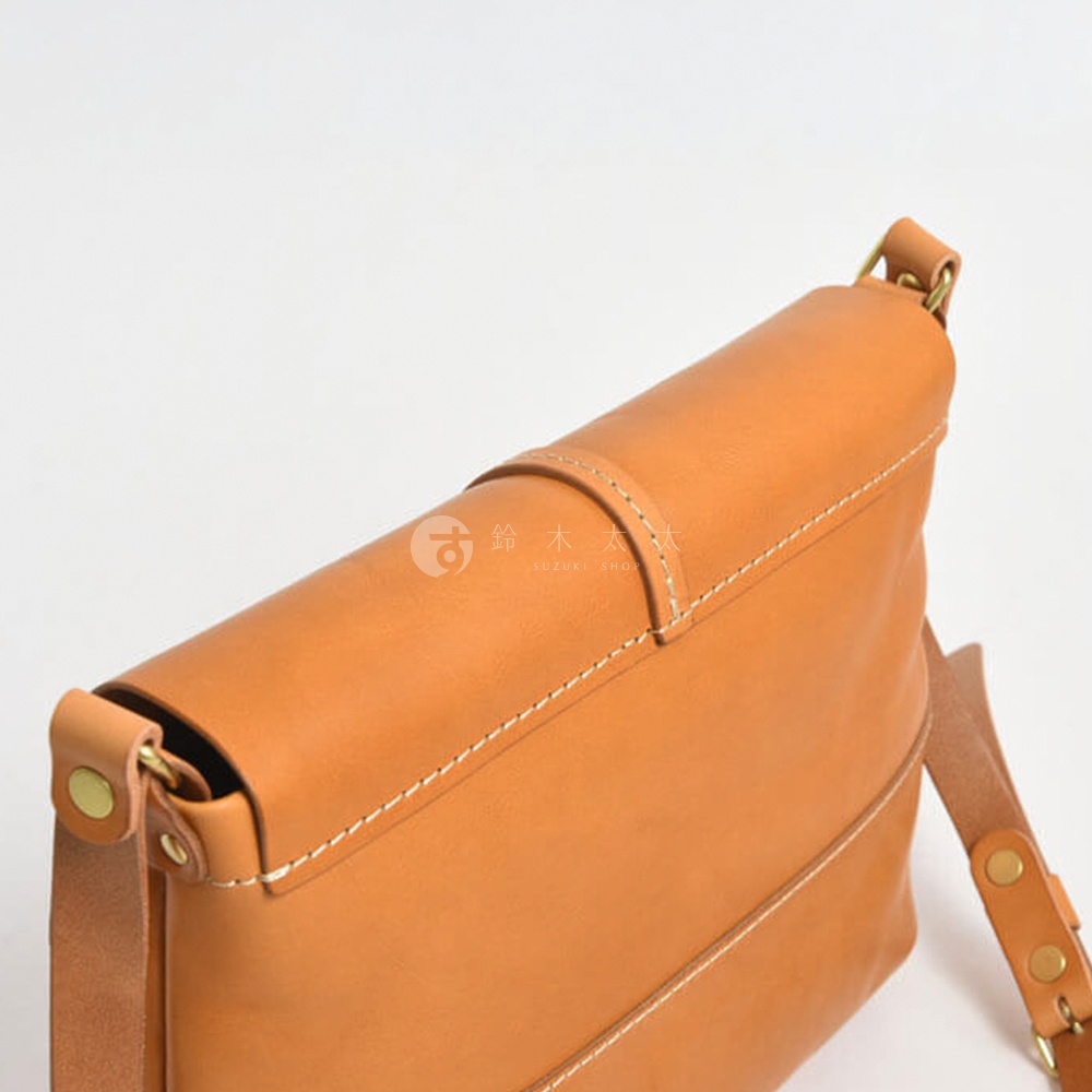 日本HERZ職人手作皮革細扣帶馬鞍包，特寫展示側邊棕褐色皮革包身和金屬扣細節