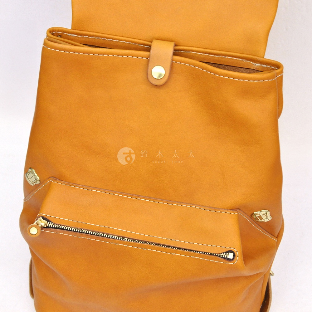 焦糖色皮革多口袋後背包，配有金色拉鍊、鈕扣及金屬裝飾，細緻車縫線。