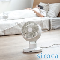白色 SF-A1610 3D 氣流循環扇，帶有可調節角度的圓形風扇頭，圓形底座上設有控制按鈕，放置於木質地板上，背景為臥室床鋪及熟睡的人。