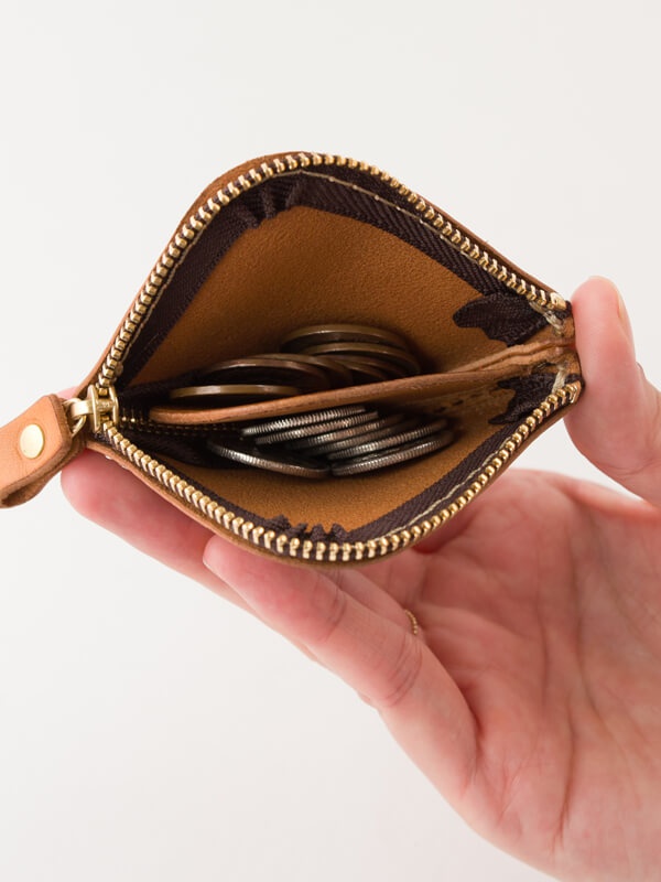 職人手作皮革分隔收納零錢包，採用原色皮革材質，內有分隔設計，裝有硬幣。