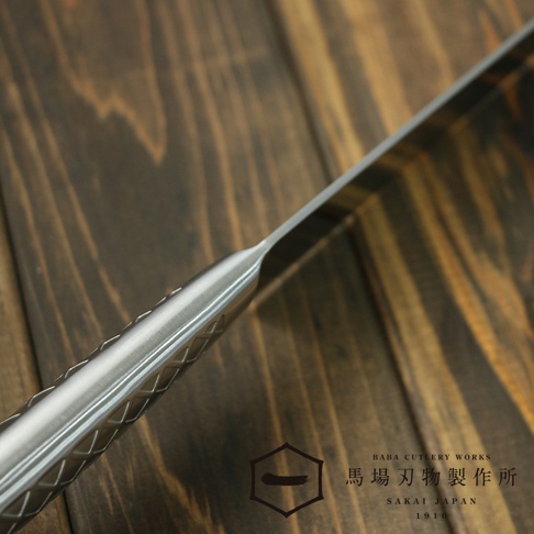 [堺一次] 不鏽鋼水果刀，刀柄採用銀色不鏽鋼材質，表面有菱形紋路，刀刃鋒利，整體呈現簡約的設計風格，背景為木質桌面。