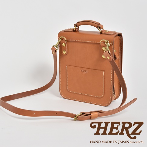 棕褐色皮革手提/斜肩兩用包，設有立體前袋、頂部提把及可拆卸肩帶，搭配金色五金配件，整體線條簡潔。