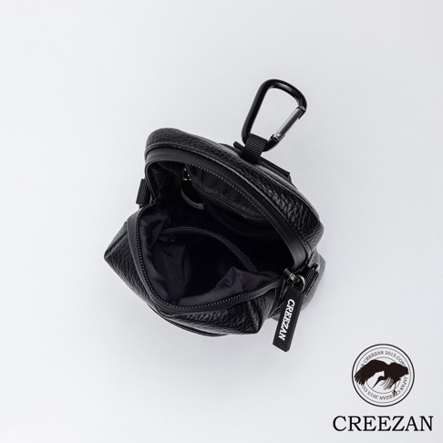 黑色荔枝紋皮革高爾夫迷你側背收納包，頂部開口，內有夾層，附有黑色登山扣和品牌吊牌。