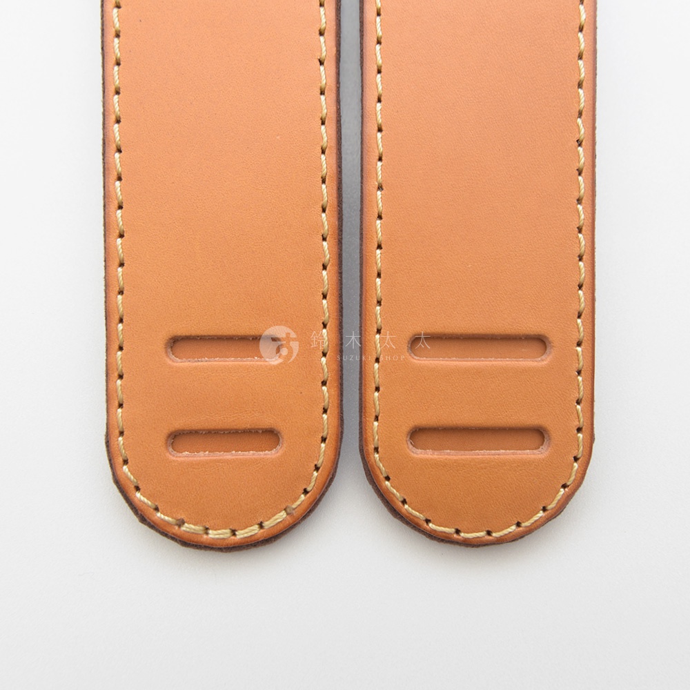 兩條棕褐色皮革肩墊，帶有米黃色縫線，兩側各有一對長方形的開孔。