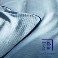 淺藍色天絲棉絎縫單人毯，質感柔軟，細緻紋理，搭配深藍色滾邊。