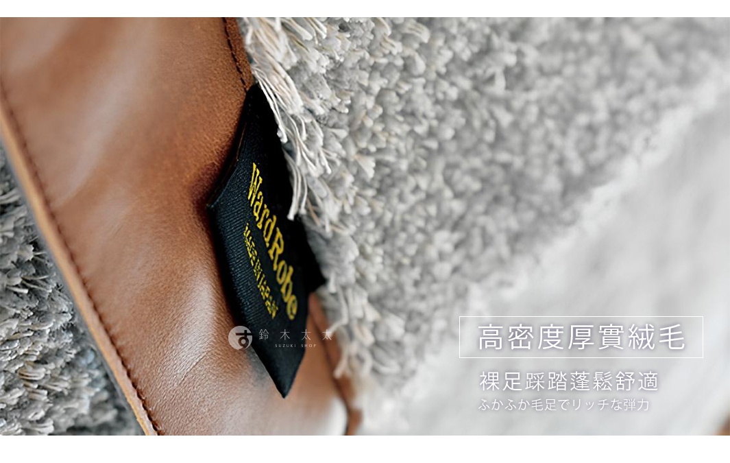 Ward Robe 玄關地墊，淺灰色高密度絨毛材質，觸感柔軟，一角有棕色皮革裝飾與品牌標籤。