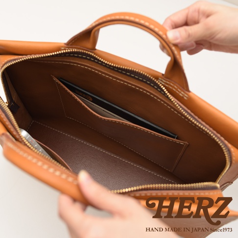 HERZ 品牌皮革公事包內側，可見卡片夾層及手機。