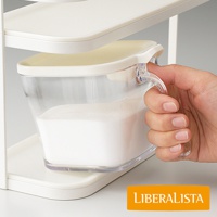 LIBERALISTA 品牌瓶罐收納架-小，特寫手部握住裝有白色粉末的透明收納罐把手，罐子放置於白色收納架上。