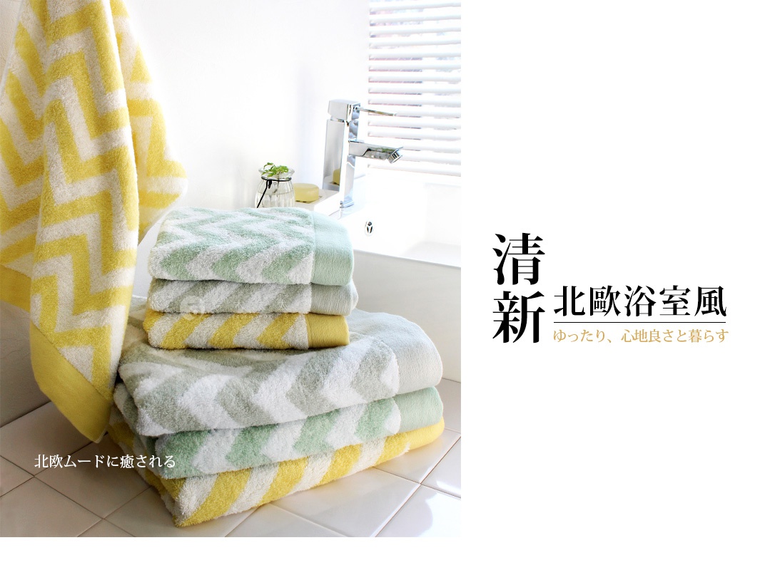 今治北歐方巾，質地柔軟，圖案為淺綠色與黃色相間的鋸齒紋，疊放整齊，一條黃色方巾懸掛在左側。