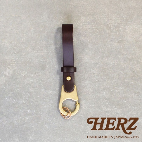 深棕色皮革鑰匙圈，配有黃銅色掛鉤和兩個銅色鑰匙環，由日本HERZ手工製作。