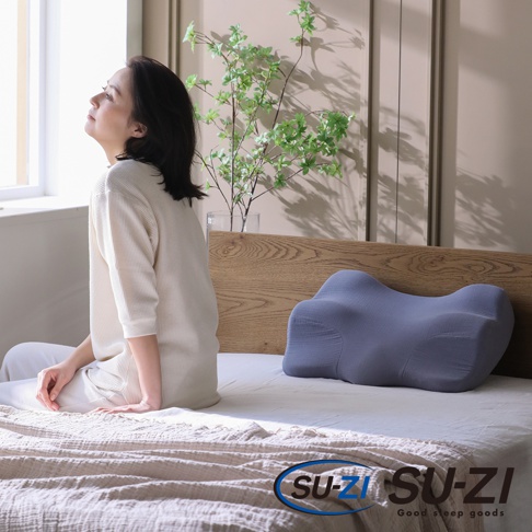 AS 快眠止鼾枕 三代，藍灰色，具有人體工學曲線設計，枕套為柔軟布料，放置於臥室床上。