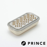 一個米白色的兩用盒，上方覆蓋著不銹鋼網蓋，網蓋上有魚骨狀的磨泥孔和長條狀的切片孔。