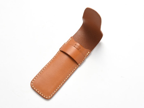 淺棕色皮革製單支鋼筆收納筆套，帶有手工縫線，筆套頂部有一條翻蓋式固定帶，內側有壓印品牌標誌。
