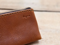 職人手作皮革Organ三角收納筆袋，M尺寸，採用棕色皮革製作，帶有壓印的「Organ」品牌標誌，搭配金色拉鍊和縫線，質感細膩。