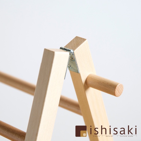 原木色木藝牆面收納架，由光滑的木質支架和金屬鉸鏈組成，呈現簡潔的A字形結構，木紋清晰可見。