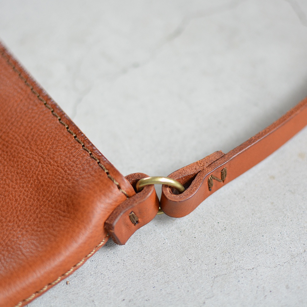 職人手作皮革Organ肩背小方包 G-26 M，特寫皮革包身與精緻車縫線，一側連接金色圓環與皮革背帶，展現天然皮革紋理與質感。