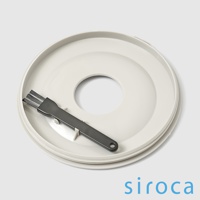 淺灰色咖啡機零件，帶有一個圓形開口，上面放置著一把深灰色清潔刷。