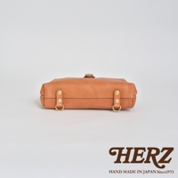 職人手作皮革迷你軟皮杜勒斯包，採用淺棕色柔軟皮革，搭配金色金屬扣環和铆釘，包身線條簡潔，展現職人手工質感。