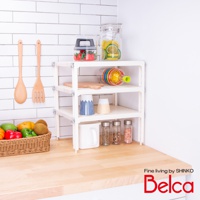 白色三層迷你收納架，架上擺放著玻璃罐裝草莓、檸檬片、七彩榨汁器、木質砧板、藍白條紋杯、米色杯、白色馬克杯及多罐調味料，架旁有木質湯勺與叉子，前方籃子裡有水果與蔬菜。