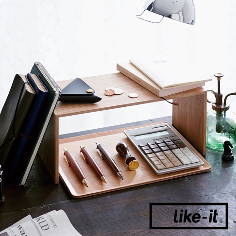 雙層木紋整理架，木紋材質，上方擺放筆記本、零錢與黑色零錢包，下方木盤上放有計算機、三支鋼筆和印章，整體簡約實用。