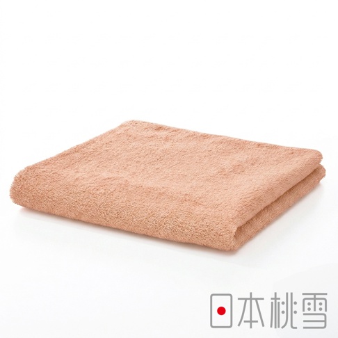 一張折疊整齊的粉膚色純棉飯店毛巾，質地柔軟蓬鬆，表面呈現細緻的毛圈纖維，整體色調柔和，右下角印有日本桃雪的品牌標誌與圖示。