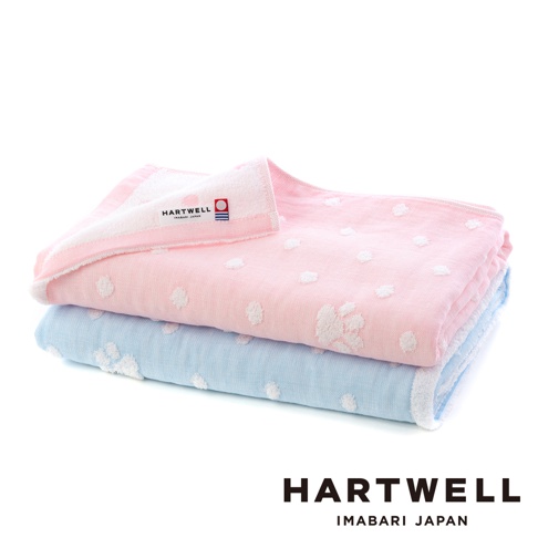 粉色與藍色今治純棉點點紗布浴巾堆疊，粉色浴巾上有白色點點圖案，藍色浴巾同樣有白色點點圖案，兩條浴巾皆有品牌標籤。