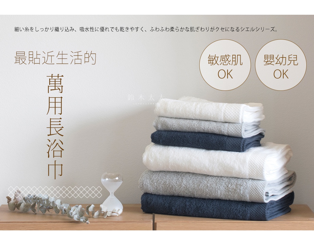 堆疊的今治純棉浴巾，呈現白色、灰色與深藍色，浴巾表面織有菱形紋路，質感柔軟吸水。