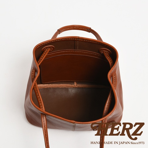 HERZ 職人手作皮革可調式兩用托特包，展示其內部結構，可見棕色皮革內袋與繫繩開口設計。