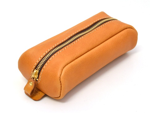 棕褐色皮革製成的圓角收納筆袋，配有黃銅拉鍊和縫線，一端有皮革拉環，上面印有品牌標誌。