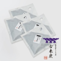四件方形白色透氣包裝的調濕木炭，內部為深灰色炭粒，包裝上有日文標籤和提孔，其中一件包裝上可見紫色繩結圖案。