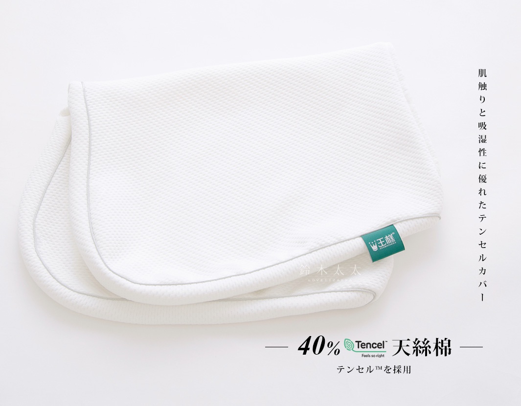 白色網格紋理的「王樣のWide&Long 極夢枕」專屬枕套，採用40%天絲棉材質，表面縫有細緻的灰色滾邊，角落處縫有品牌綠色標籤。
