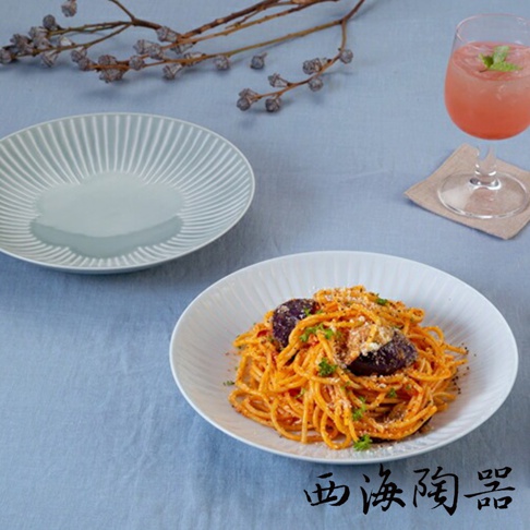淡藍色與白色兩件式主食盤，皆有細緻的放射狀紋路，盤中盛裝著義大利麵，搭配乾燥枝條與飲料，呈現日式餐桌風格。