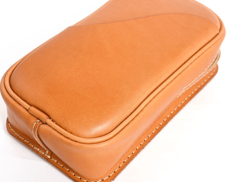 淺棕色皮革製作的職人手作兩用直立型斜背包，包身線條圓潤，邊緣有明顯的白色車縫線，材質紋理清晰可見。