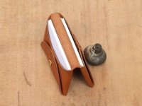 職人手作皮革Organ雙開卡片收納夾 (GS-41)，淺棕色皮革材質，開啟狀態，露出內層的白色卡片，整體放置於木質紋理背景上，旁邊有一個金屬小物件。