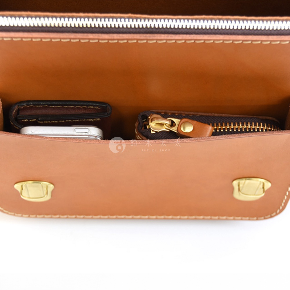 棕色皮革雙扣兩用單肩包，內部展示，可見錢包、手機和拉鍊零錢包。