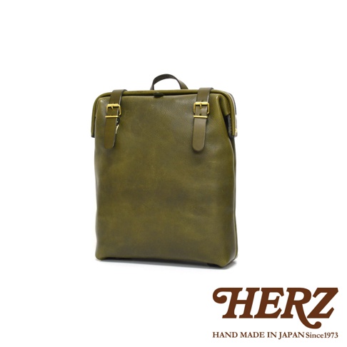 職人手作皮革後背包 R-143，橄欖綠色，採用天然皮革製成，設計簡約，帶有兩個可調節的皮帶和金色扣環。