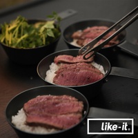 三個黑色圓形鐵杯，盛有白飯和切片烤牛肉，其中一個杯子由夾子夾著。背景有一個黑色碗，裝有綠色蔬菜。