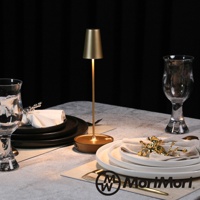 金屬復古氛圍燈，燈罩呈圓錐狀，燈身細長，底座為圓形。燈身及燈罩為金色，整體散發溫暖光芒。