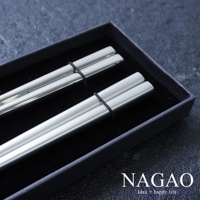 一組兩雙燕三條不鏽鋼筷，每雙長 22.3 公分，筷子呈現銀灰色，表面經過霧面處理，以黑色細繩固定於黑色禮盒中。