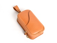 職人手作皮革兩用直立型斜背包，採用淺棕色皮革，帶有縫線細節，正面有弧形設計，附有拉鍊開合及掛環。