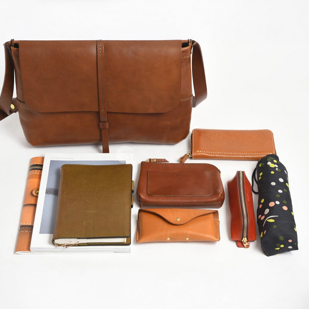 HERZ 職人手作皮革細扣帶馬鞍包，搭配多款周邊皮件，包括長夾、化妝包、零錢包，以及一只點點摺疊傘。