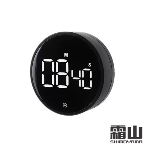 這是一款日本霜山品牌的黑色圓形電子定時器，正面設有黑底白光的數字顯示螢幕，顯示目前設定時間為八分四十秒，螢幕正下方有一個圓形觸控感應標記，整體設計簡約現代，適合居家環境使用。